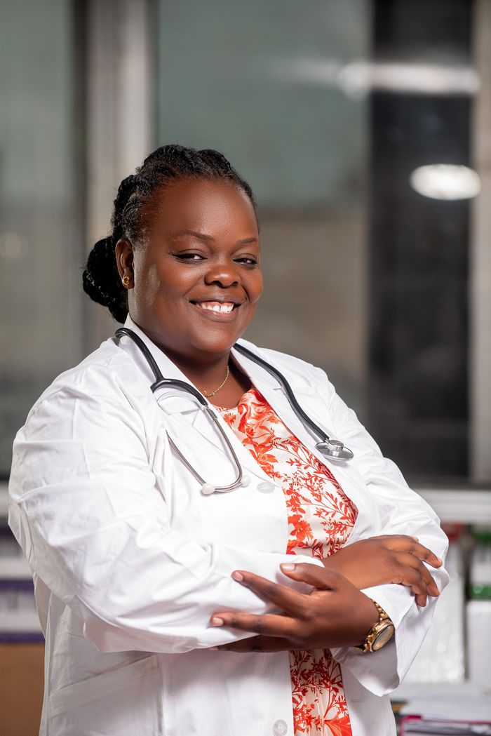 gallery-01 Confident African medical professional smiling in clinic, representing healthcare in Kinshasa.